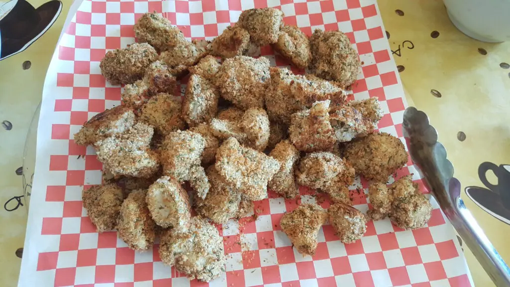 Breaded chicken pieces on checkered paper.