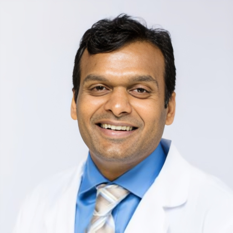 Smiling man in a white coat.