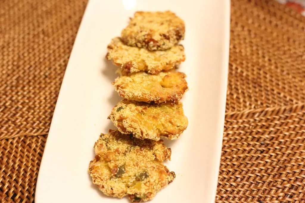 Fried fritters on a white rectangular plate.