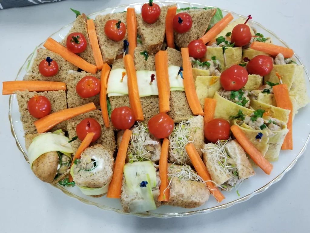 Assorted finger sandwiches with vegetables and tomatoes.