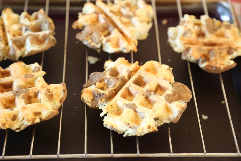 Waffle pieces cooling on a wire rack.