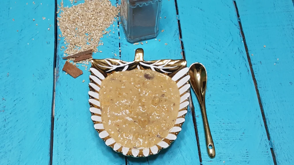 Bowl of oatmeal with spoon on table.