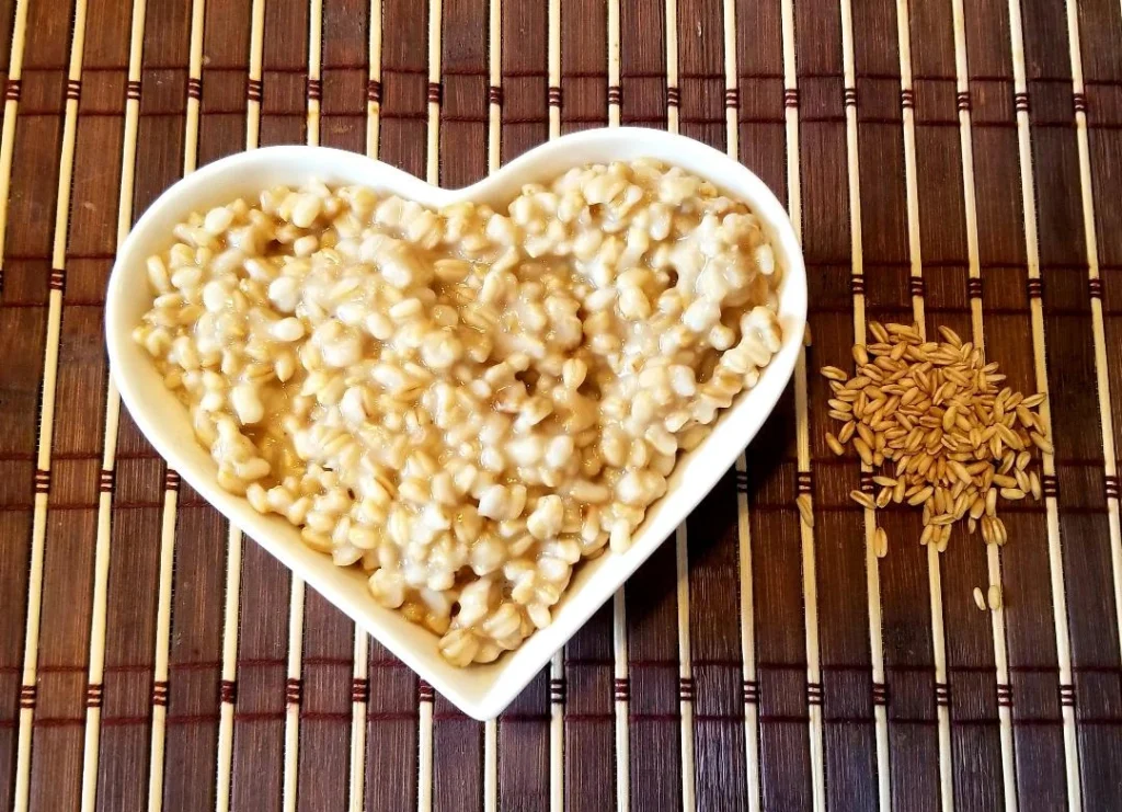 Heart-shaped bowl with cooked barley grains.