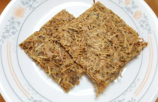 Two slices of dried fish on plate.