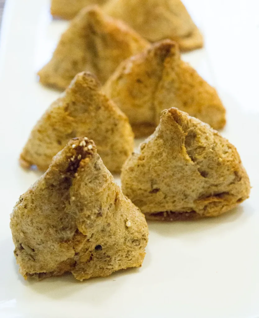 Brown triangular pastries on a white plate.