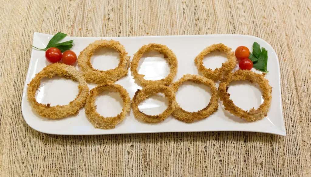 Onion rings on a white plate.