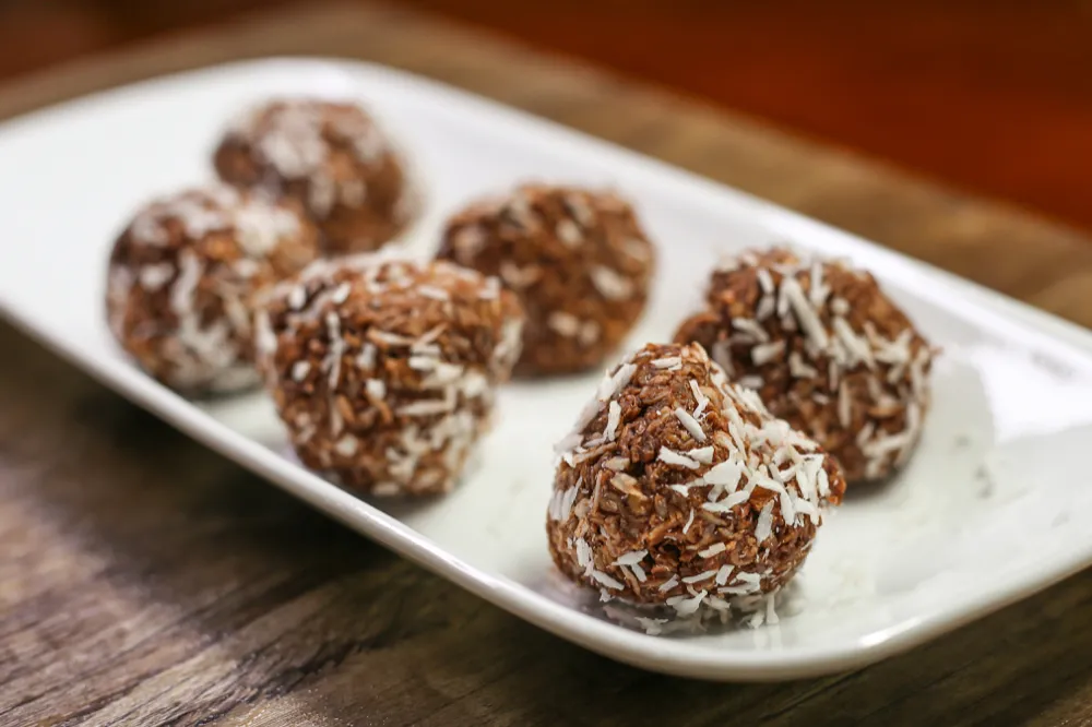 Chocolate coconut balls on a white plate.