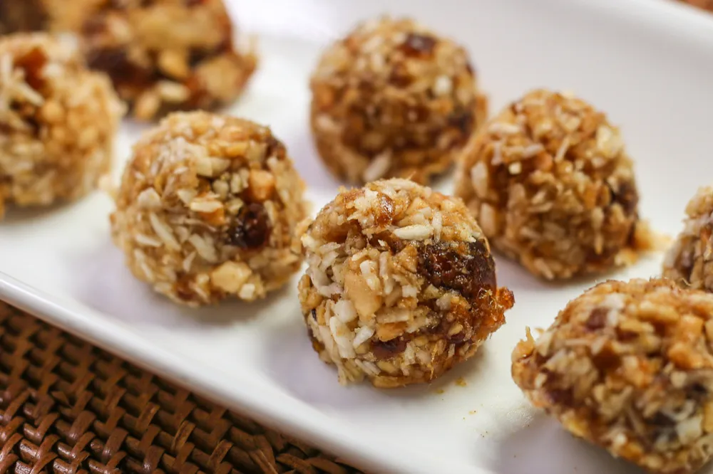 Nut and coconut energy bites on plate.