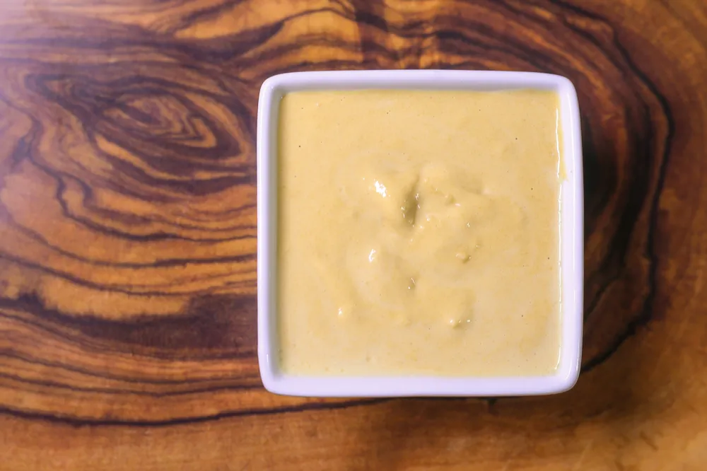 Square dish with creamy yellow sauce.