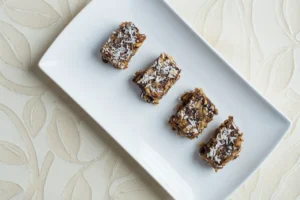 Four dessert bars on a white plate.