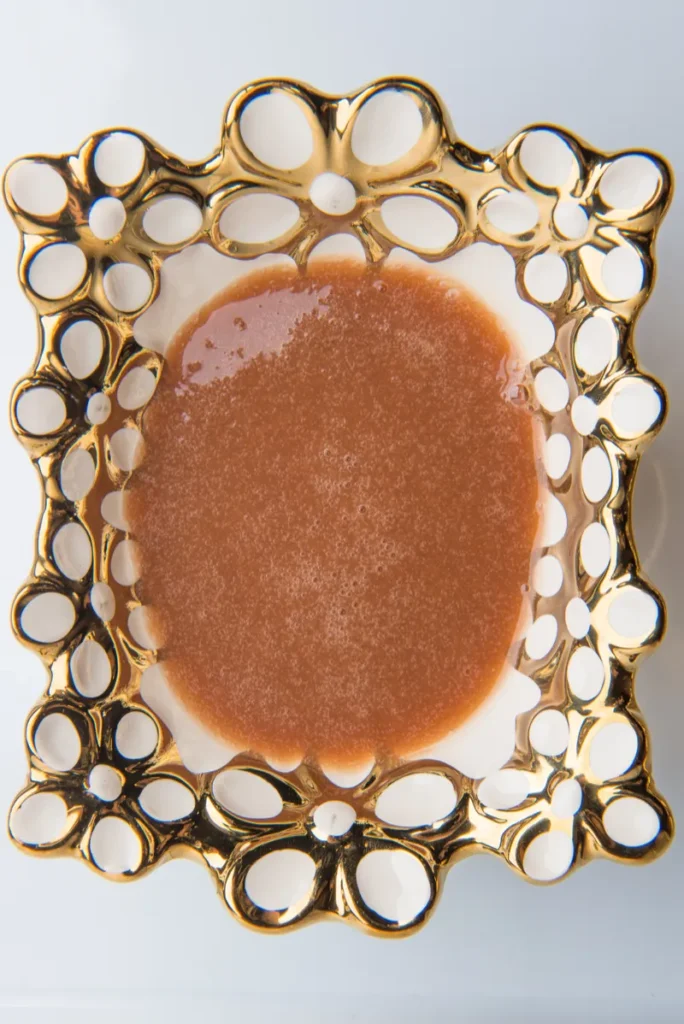 Golden decorative plate with brown liquid inside.