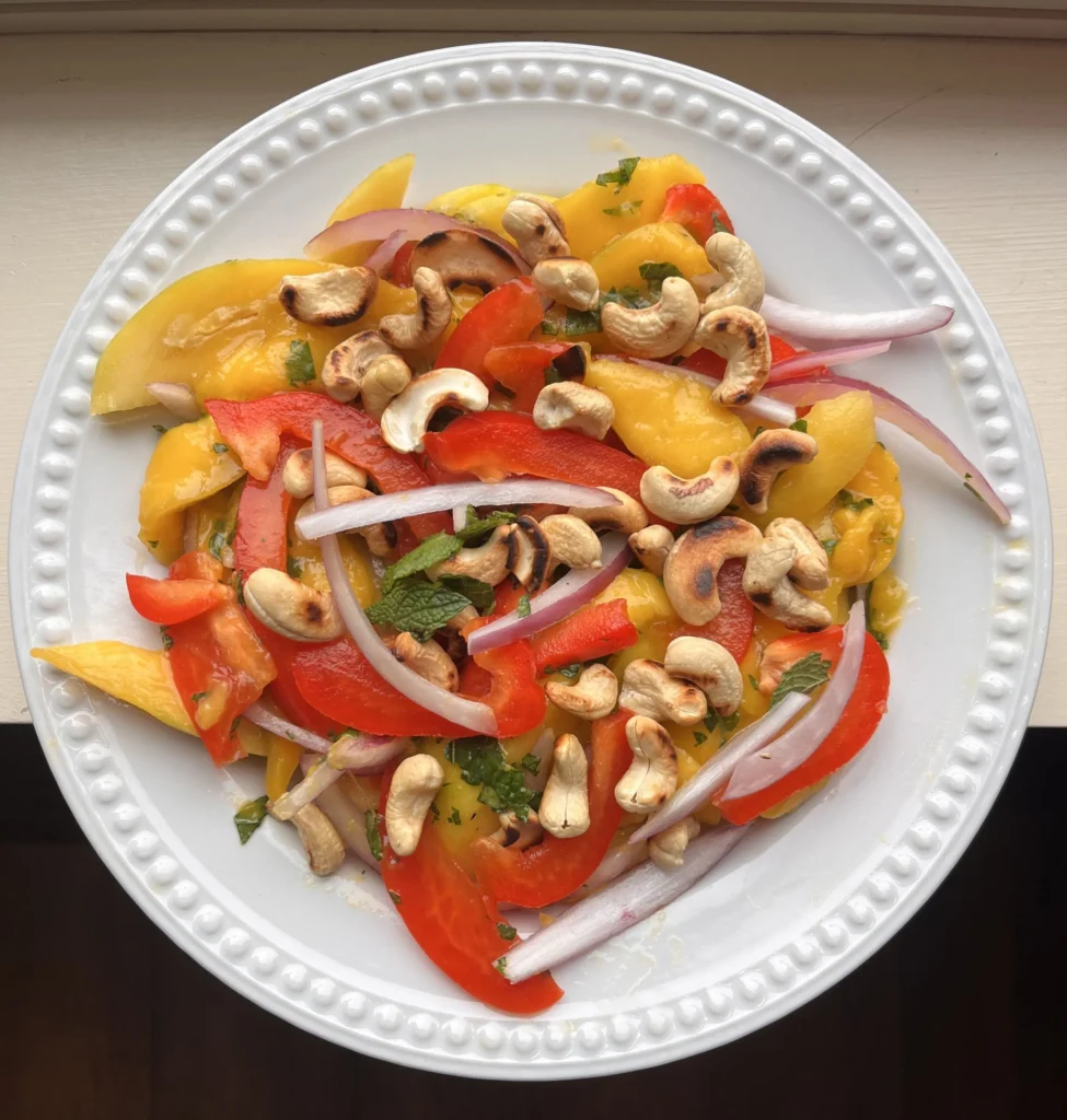 Colorful salad with cashews and sliced vegetables.