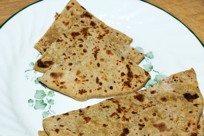 Flatbreads on a decorative white plate.