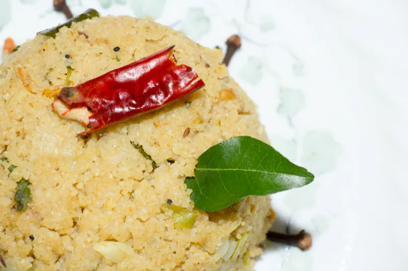 Spicy upma garnished with red chili.
