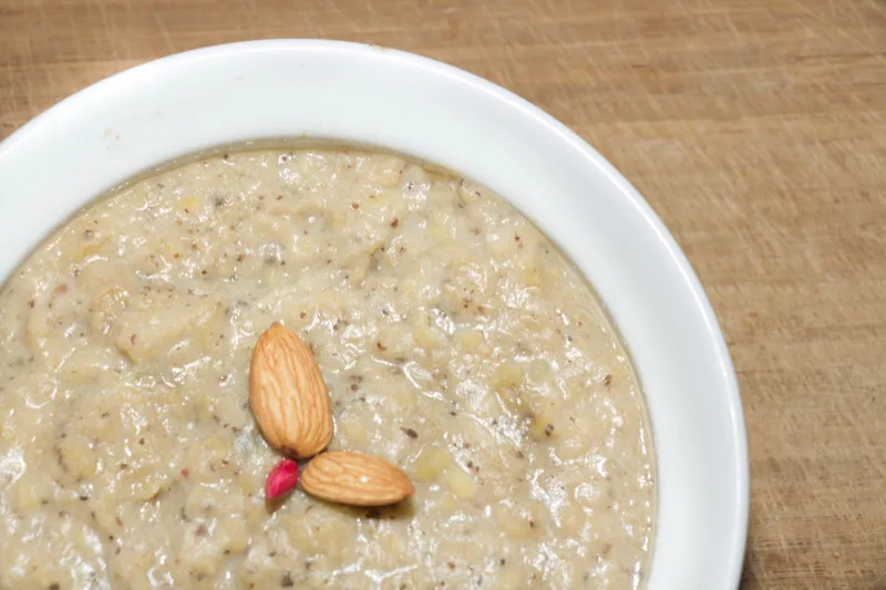 Creamy porridge with almonds in bowl.