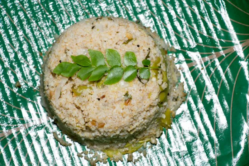 Coconut rice with curry leaves on plate.