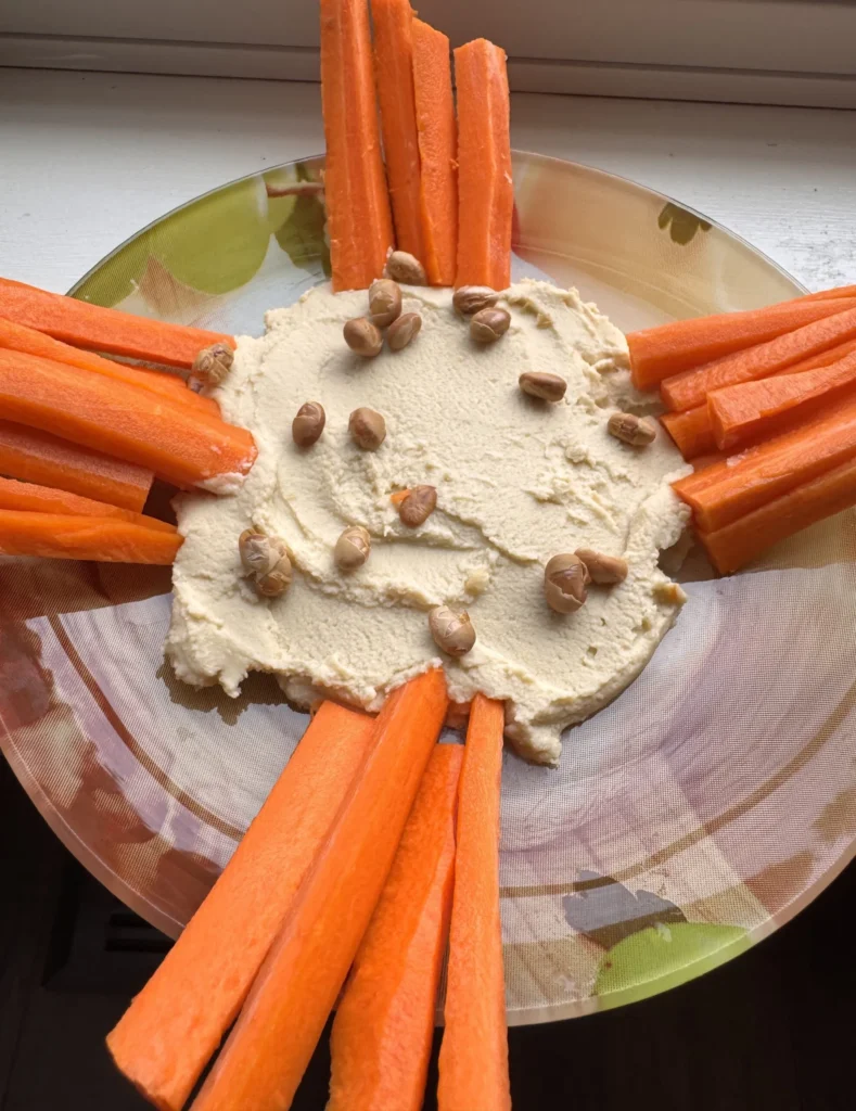 Carrot sticks with hummus and nuts.