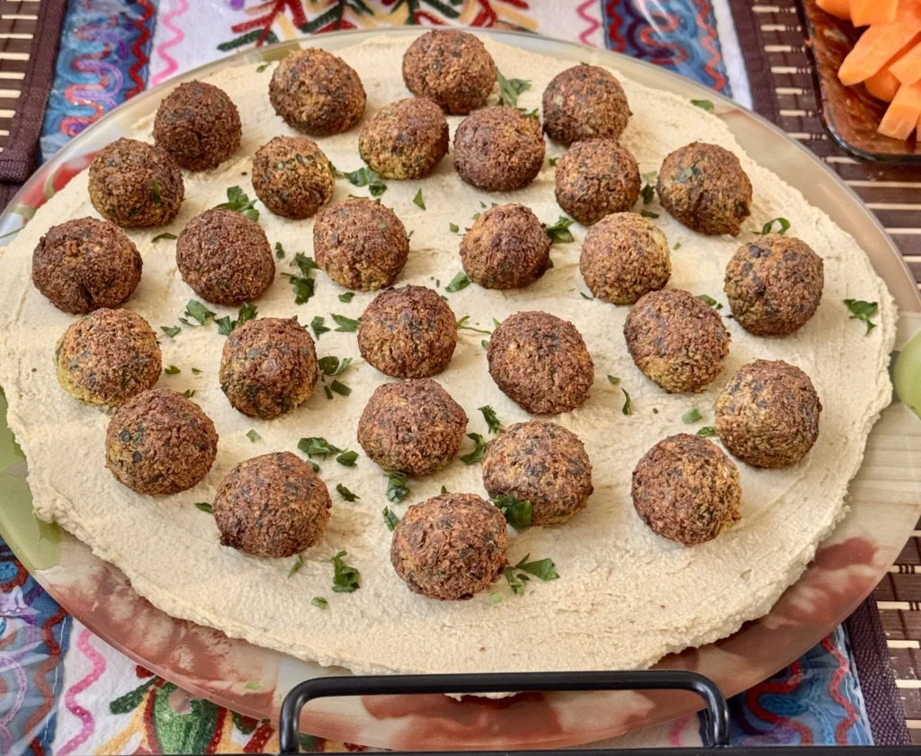 Falafel balls on a bed of hummus.