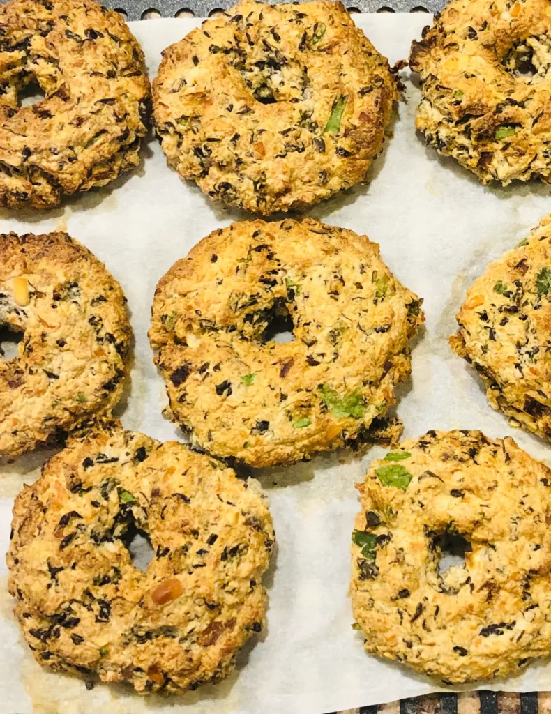 Homemade baked bagels on parchment paper.