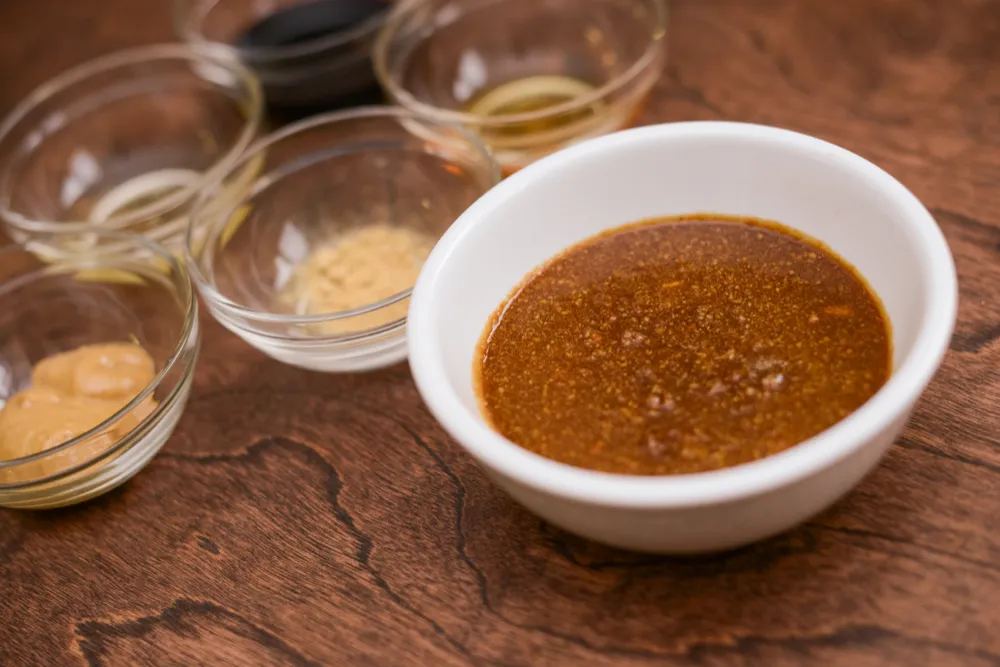 Bowl of sauce with ingredients in background.