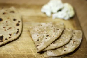 Flatbread slices on a wooden board.