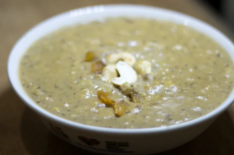 Bowl of creamy pudding with nuts garnish.