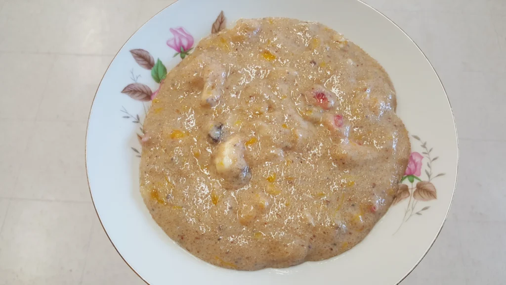 Bowl of creamy porridge with fruits.