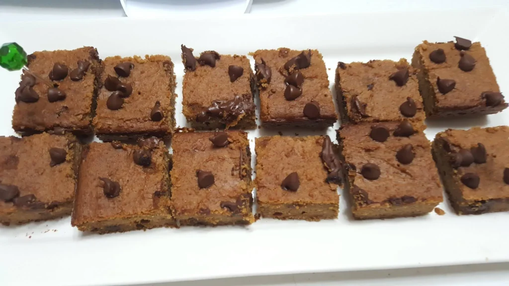 Chocolate chip brownies on a white plate.