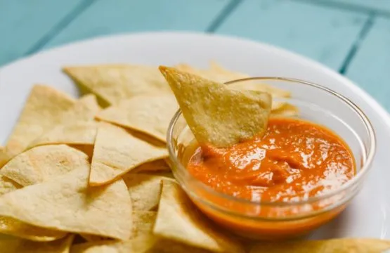 Tortilla chips with red salsa dip.
