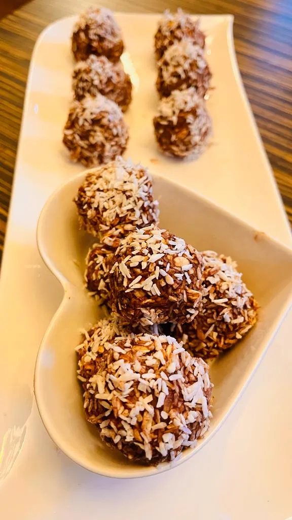 Coconut-covered chocolate truffles on a plate.