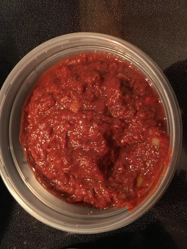 Red sauce in a clear plastic container.