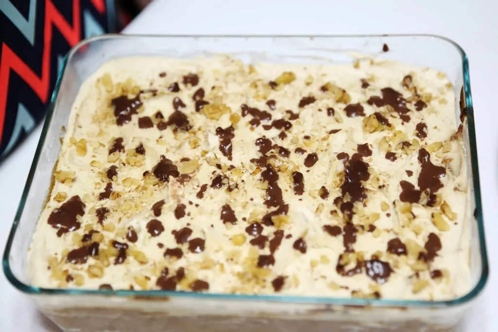 Dessert topped with chocolate and nuts.