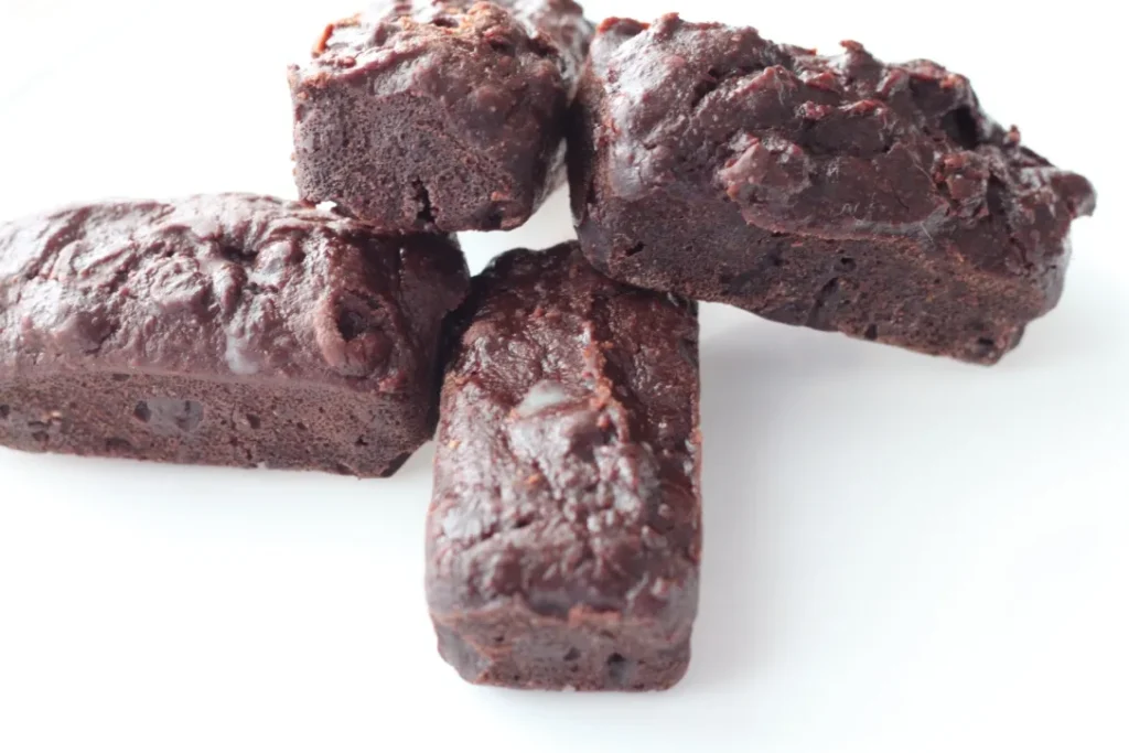 Four chocolate brownies on a white background.