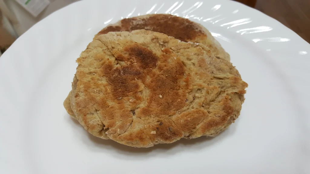 Two pieces of bread on white plate.