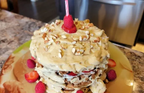 Layered cake with berries and single candle.