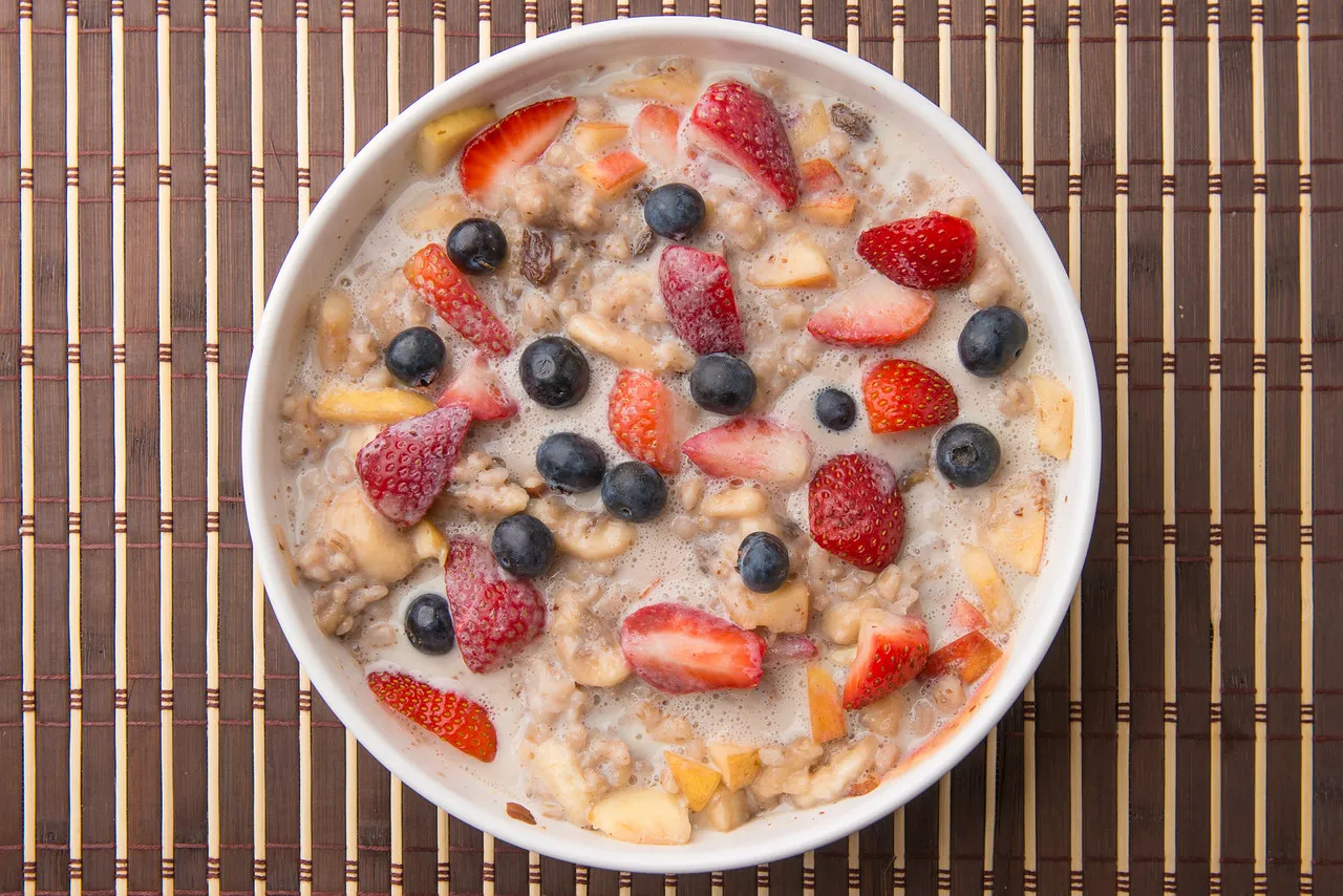 Bowl of oatmeal with mixed fruits.