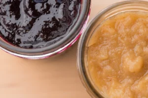 Two jars of jam and applesauce.